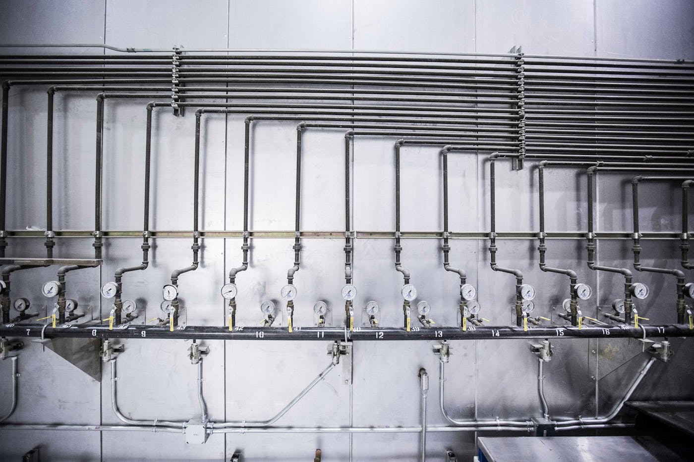 Newly installed industrial steel pipework with pressure gauges and valves